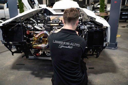Technician working on luxury vehicle engine components at Legends Auto Boutique, showcasing performance enhancements and meticulous automotive care.